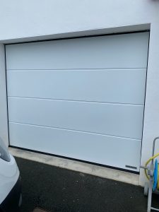 Porte de garage sectionnelle Hörmann rainures L finition Silkgrain motorisation FAAC installée par AED64